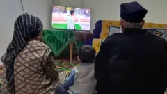 Телевизор қаршисида