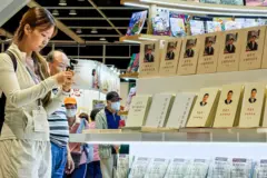 Um visitante fotografa livros do presidente chinês Xi Jinping expostos em um estande durante a Feira do Livro de Hong Kong, em 16 de julho de 2026, em Hong Kong, China.