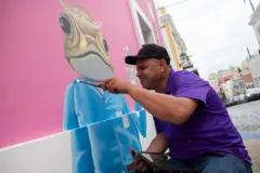 Artista pintando um sapo-concho em um mural