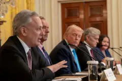David Sacks falando em um microfone durante uma reunião na Casa Branca. Na mesa há várias pessoas, entre elas o presidente Donald Trump