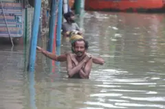 ফেনীর ছাগলনাইয়ায় বুক সমান বন্যার পানির মধ্য দিয়ে হেঁটে আসছেন দু'জন
