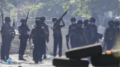Police officers search for hiding demonstrators