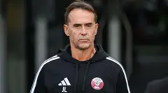 Julen Lopetegui Katar FA markalı kapüşonlu üst giyiyor.
