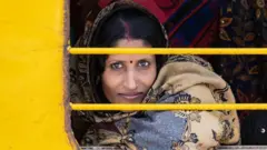 రైలు కిటికీలోంచి చూస్తున్న మహిళ