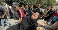 Mulher chora em Gaza, com multidão ao redor