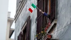 Pessoa segura bandeira da Itália em Roma