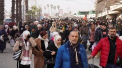 Çok sayıda sivilin evlerini terk ederek geniş bir yolda yürüdüğü görülüyor. Fotoğrafta yüzlerce kişi var.