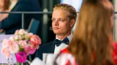 Marius Borg Høiby'nin 2022 yılında Oslo'da katıldığı bir davette çekilmiş bir fotoğrafı. Üzerinde siyah bir smokin ve ve sola doğru bakıyor. 