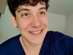 Henry Gaudêncio Almeida olha para a câmera sorrindo e veste camiseta azul