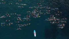 Tomada aérea dos competidores nadando no Ironman havaiano