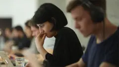 Une femme au travail parmi des hommes