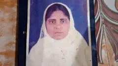 A passport photo of Hamida Banu, wearing a white scarf.