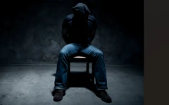 Ọkùnrin tó da aṣọ bojú tí wọ́n fi sínú yàrá dúdú