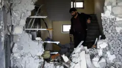 رجل يتفقد منزله المدمر في أذربيجان