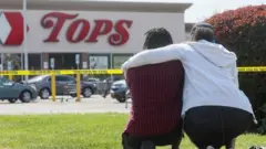 Two mourners outside the Tops Friendly Market in Buffalo