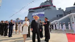 Kim Jong-un e sua filha durante o relançamento do navio de guerra norte-coreano que havia virado na primeira tentativa