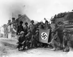 Des soldats exhibent un drapeau nazi capturé
