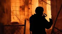 силуэт пожарного на фоне сильного огня