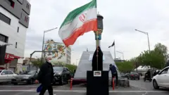 伊朗德黑蘭街頭一位身穿全身罩袍的女士揮舞國旗（12/4/2026）