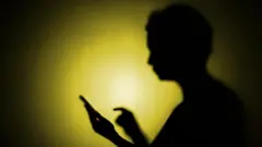 ظل طفل يمسك بهاتف محمول 