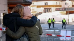 Две девушки в зимних куртках, одна в розовой шапке, вторая без головного убора, стоят, обнявшись за плечи, перед красно-белой полицейской лентой, огораживающей бар Le Constallation. За оцеплениием на заднем плане идут трое полицейских в ярких желто-зеленых жилетах