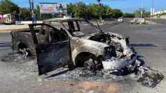 Mobil yang terbakar setelah bentrokan antara aparat keamanan federal dan kelompok bersenjata menyusul penangkapan Ovidio Guzman, tersangka bandar narkoba dan anak "El Chapo" Guzman.