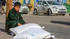 Criança ao ladobwin élőmantimentos pela agência da ONUbwin élőGaza