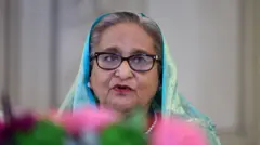 Шейх Хасина - пожилая седоватая женщина в очках и синем платке