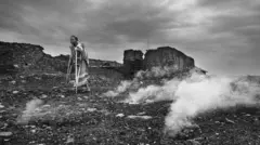 Une ouvrière dalit (anciennement connue sous le nom d'intouchable) passe devant une mine de charbon à ciel ouvert dans l'État indien du Jharkhand