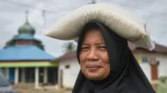 Warga membawa karung beras bantuan di Desa Huta Godang, Batang Toru, Tapanuli Selatan, Sumatera Utara, Selasa (17/2/2026). Sebanyak 103 warga penyintas bencana banjir dan longsor di desa tersebut menerima bantuan paket sembako dari Ranting Muhammadiyah Tapanuli Selatan untuk memenuhi kebutuhan ibadah puasa Ramadhan 1447 H. 