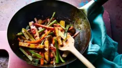 Un sauté végétarien fait à l'aide de restes de tiges de brocoli et servi dans une sauce pimentée aux haricots pour un dîner rapide et facile, qui réduit les déchets alimentaires...