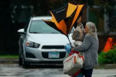 Mulherbet365 200 bonusestacionamento segurando sacolas e guarda-chuva quebrado por conta dos ventos