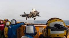 Militares americanos a bordo do navio de assalto anfíbio USS Boxer observam um caça americano em voo. Foto de arquivo.