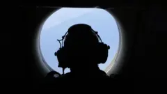 Un miembro de la tripulación a bordo de un avión antisubmarino y de vigilancia marítima P-3C Orion de la Armada alemana escanea el mar en busca de barcos el 16 de mayo de 2023 sobre el mar Báltico.