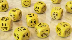 Dados com rostos de emoções