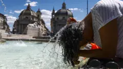 Женщина окунает голову в фонтан на фоне собора