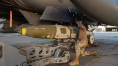 تصویر ارائه‌شده از ارتش آمریکا که در آن یک سرباز در حال قراردادن مهمات برای حمله ماه گذشته در سوریه است.