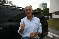 Nasry Asfura levanta el pulgar y sonríe.