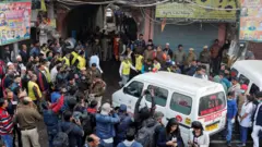 An ambulance makes its way towards the site of a fire that swept through a factory