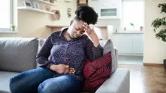 Mace zaune tana riƙe da cikinta