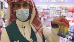 gökkuşağı renklerinde bir oyuncak tutan suudi yetkili