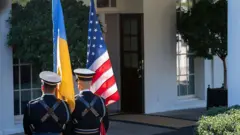 Варта біля білого дому тримає прапори України та США 