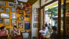 Foto do paladar La Vitrola, com pessoas sentadas às mesas comendo.