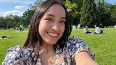 Alexandra Flores dans un parc londonien ensoleillé.
