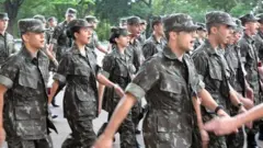 Homens e mulheres do Exército marchando