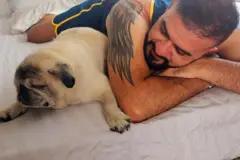 Manoel ao lado de seu cachorro pug