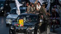 افراد طالبان در کابل سوار بر خودرو و بشکه زرد روی آن