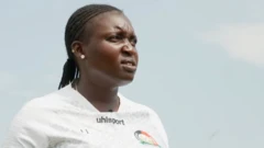 Jackline Juma is pictured wearing a white training shirt, with her black hair braided and two earrings in her right ear