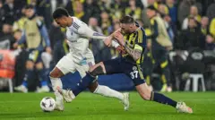 İki oyuncu topun peşinden koşuyor.