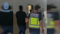 Captura de tela do vídeo do Ministério do Interior mostrando homem de costas sendo levado pela polícia